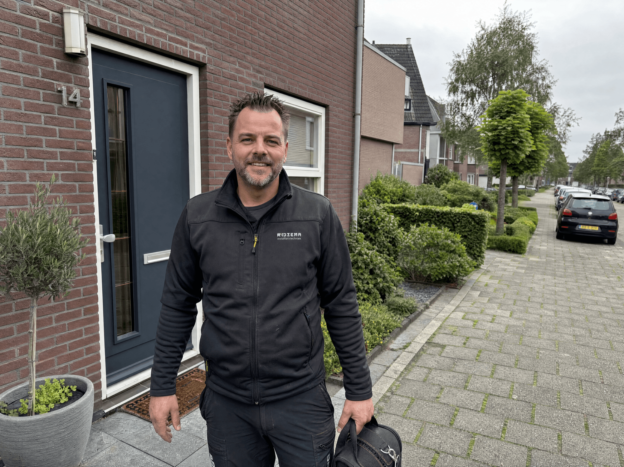 Een lokale installateur bij een Nederlandse woning in een herkenbare wijk
